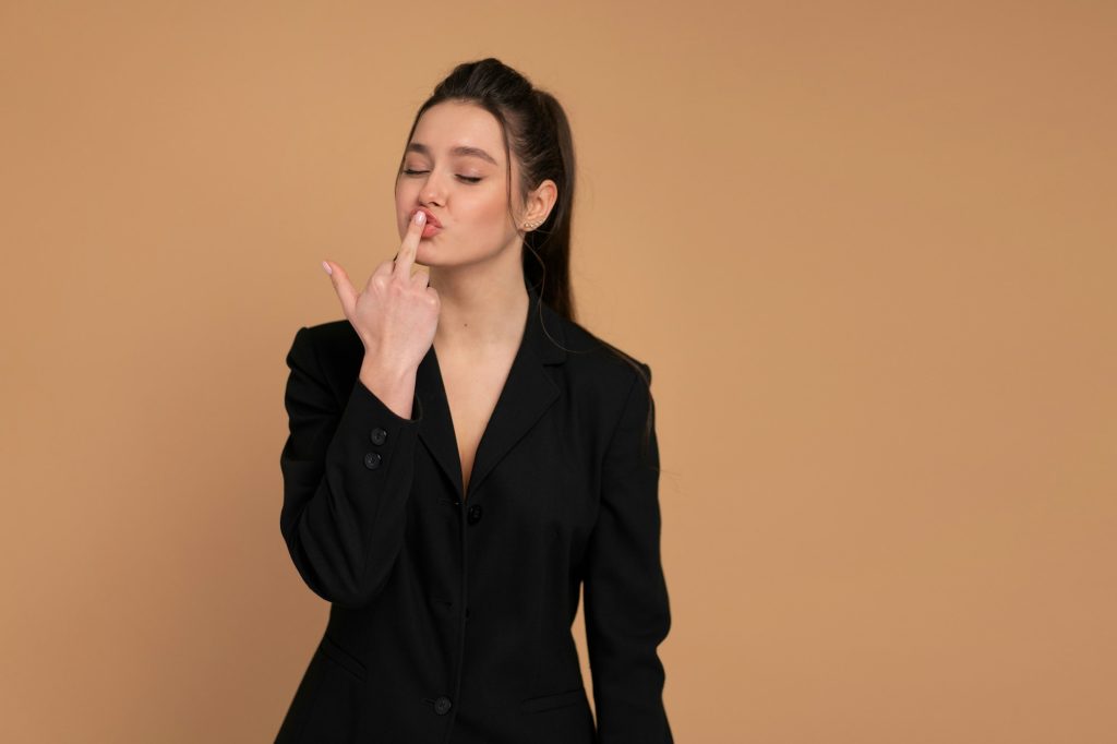 Woman making obscene hand gesture Young beautiful business woman kissing middle finger