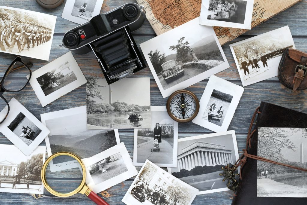 Vintage Travel concept - old photographs with camera compass map flat lay