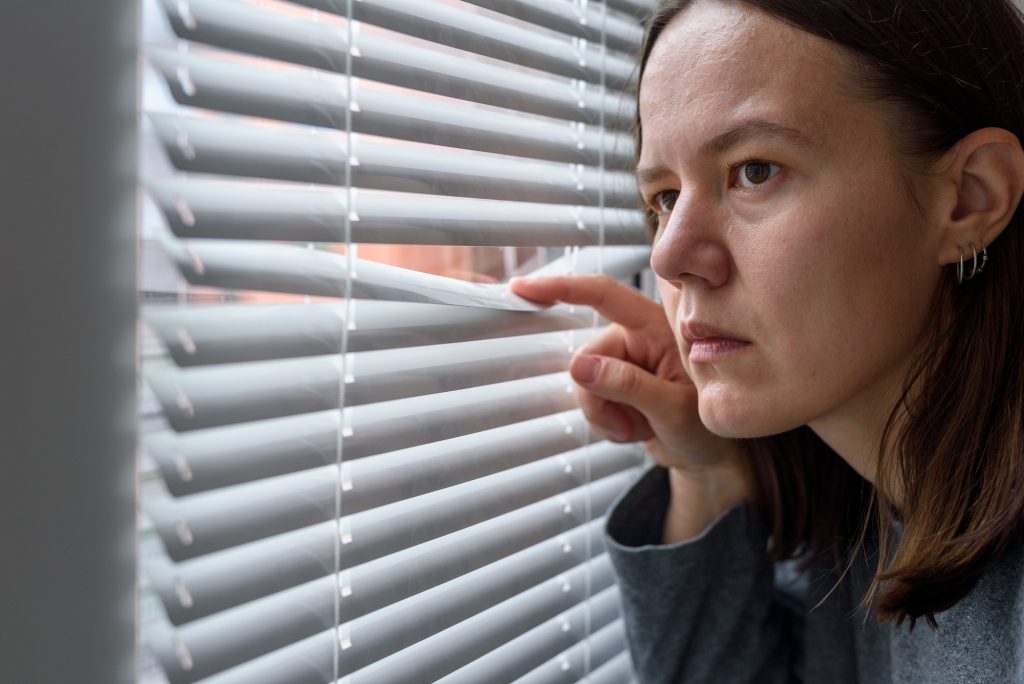 Anxious woman looking to window