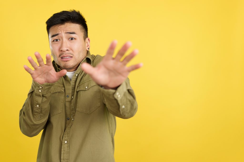 Chinese man gesturing with the hands in fear