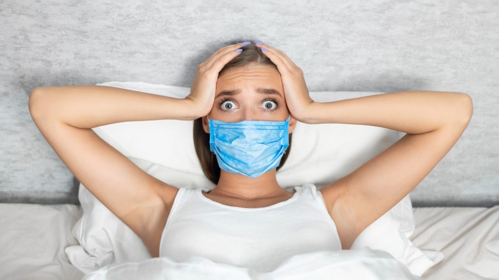 Scared Woman Touching Head In Fear Lying In Bed Indoor