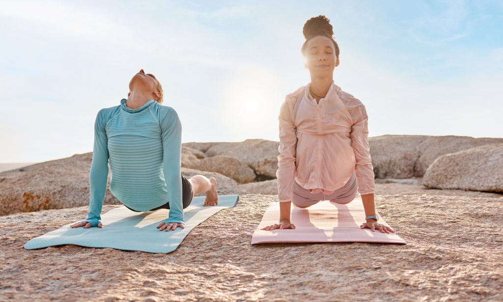 L’importance du bien-être mental et des pratiques alternatives pour une vie équilibrée Yoga, fitness and friends on the beach together for mental health, wellness or meditating in summer