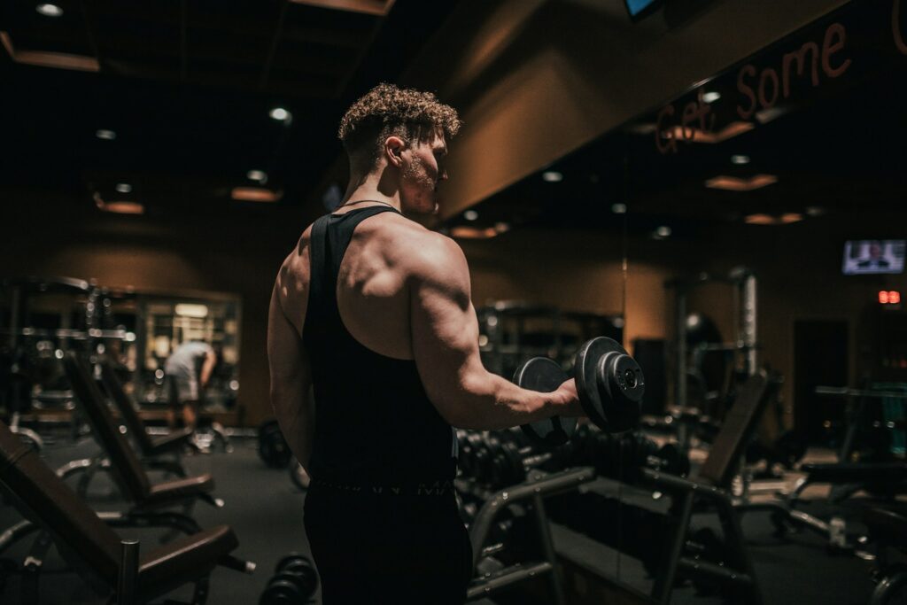 Quand votre cerveau décide de vos performances : la face cachée du rituel pré-entraînement a man holding a dumbbell in a gym