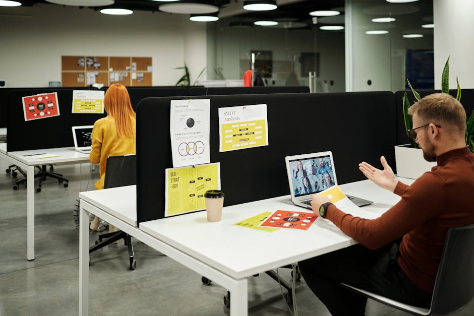 Corporate office team meeting with some empty desks in the background