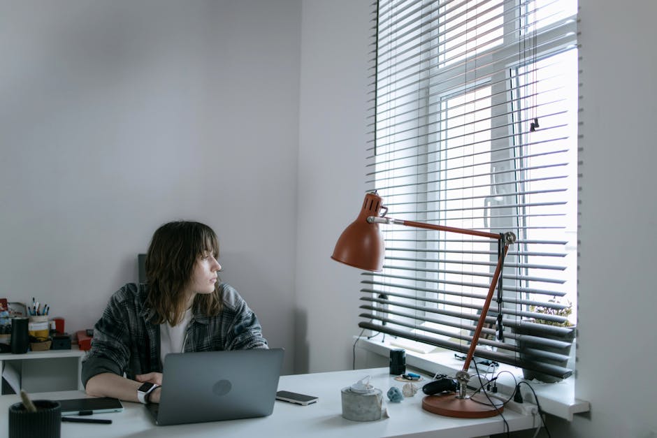 Télétravailleur isolé devant un écran d’ordinateur dans un espace de travail à domicile