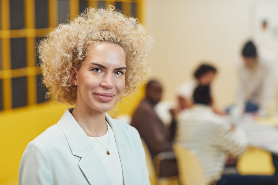 Professional woman in a tailored blazer standing confidently in a modern office