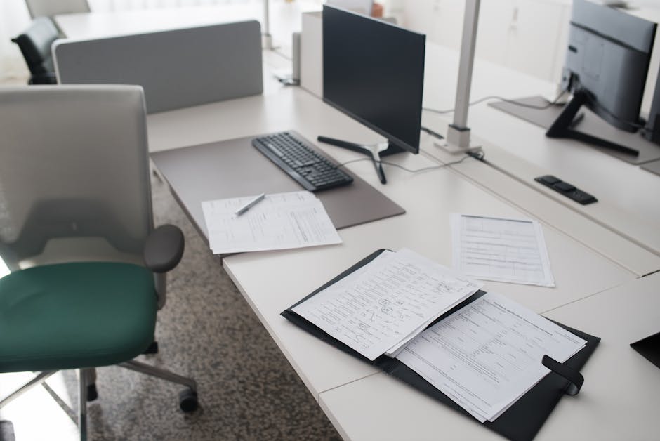 Empty shared desks in a modern office with personal items absent